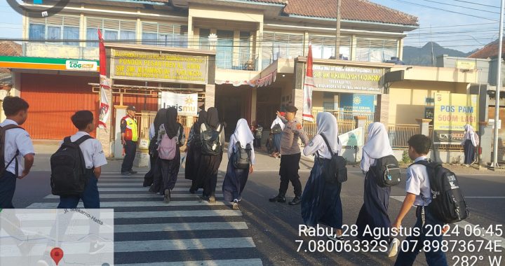 Unit Samapta Polsek Kadungora Polres Garut Pelayanan kepada Masyarakat Membantu Menyebrangkan Masyarakat dan Anak Sekolah.