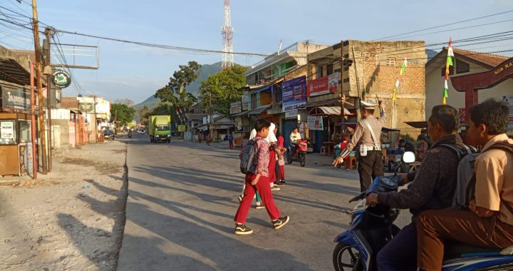 Personil Unit Lalu Lintas Polsek Kadungora Polres Garut memberikan pelayanan Kepada Masyarakat yang akan beraktivitas dan menyebrangkan Anak Sekolah mencegah terjadinya Kemacetan dan Laka Lantas.