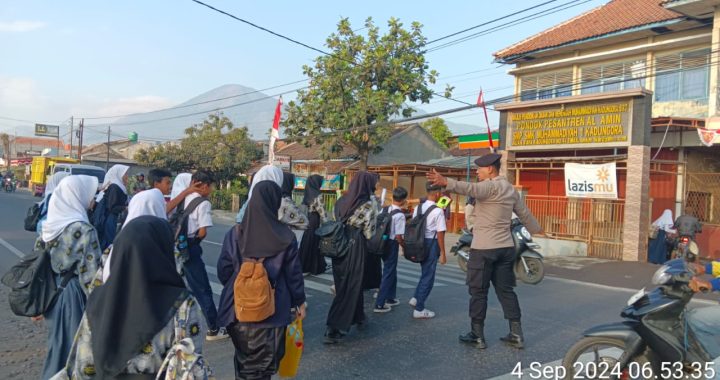 Unit Samapta Polsek Kadungora Polres Garut memberikan Pelayanan kepada Masyarakat Membantu Menyebrangkan Anak Sekolah cegah terjadinya Laka Lantas.