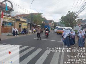 Anggota Samapta Polsek Kadungora memberikan Pelayanan kepada Masyarakat Membantu Menyebrangkan Anak Sekolah cegah terjadinya Laka Lantas.