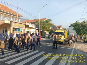 Anggota Polsek Kadungora Hadir di tengah masyarakat Berikan Pelayanan Pengaturan Lalu Lintas dan membantu menyeberangkan Anak Sekolah