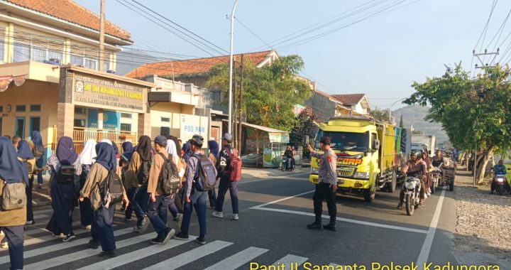 Anggota Polsek Kadungora Hadir di tengah masyarakat Berikan Pelayanan Pengaturan Lalu Lintas dan membantu menyeberangkan Anak Sekolah