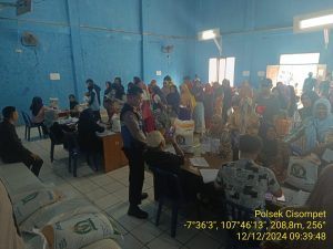 Bhabinkamtibmas desa depok bripka dinar ali hidayat melaksanakan monitoring pembagian bantuan.